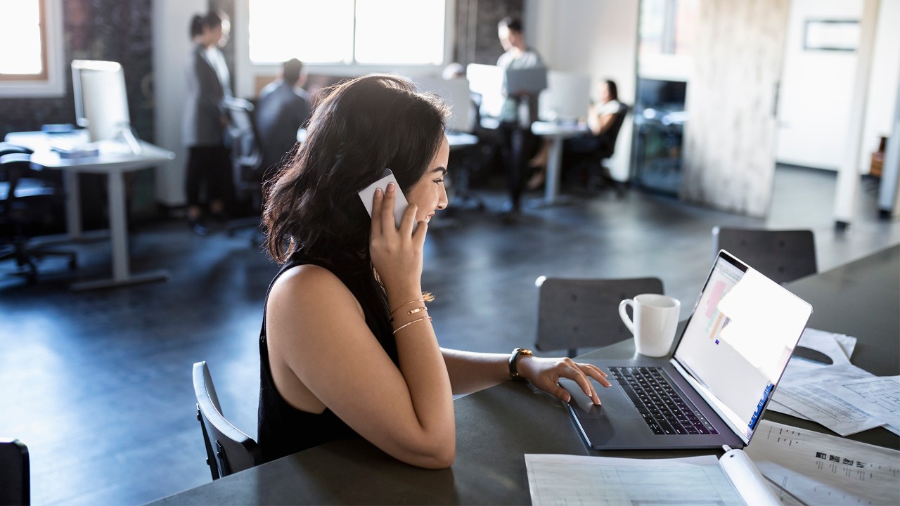 A woman is talking with her teammate by mobile; image used for nettrader page