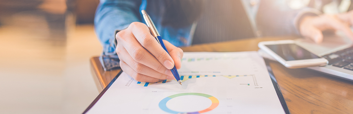 A man is writing a financial report; image used for Digital services